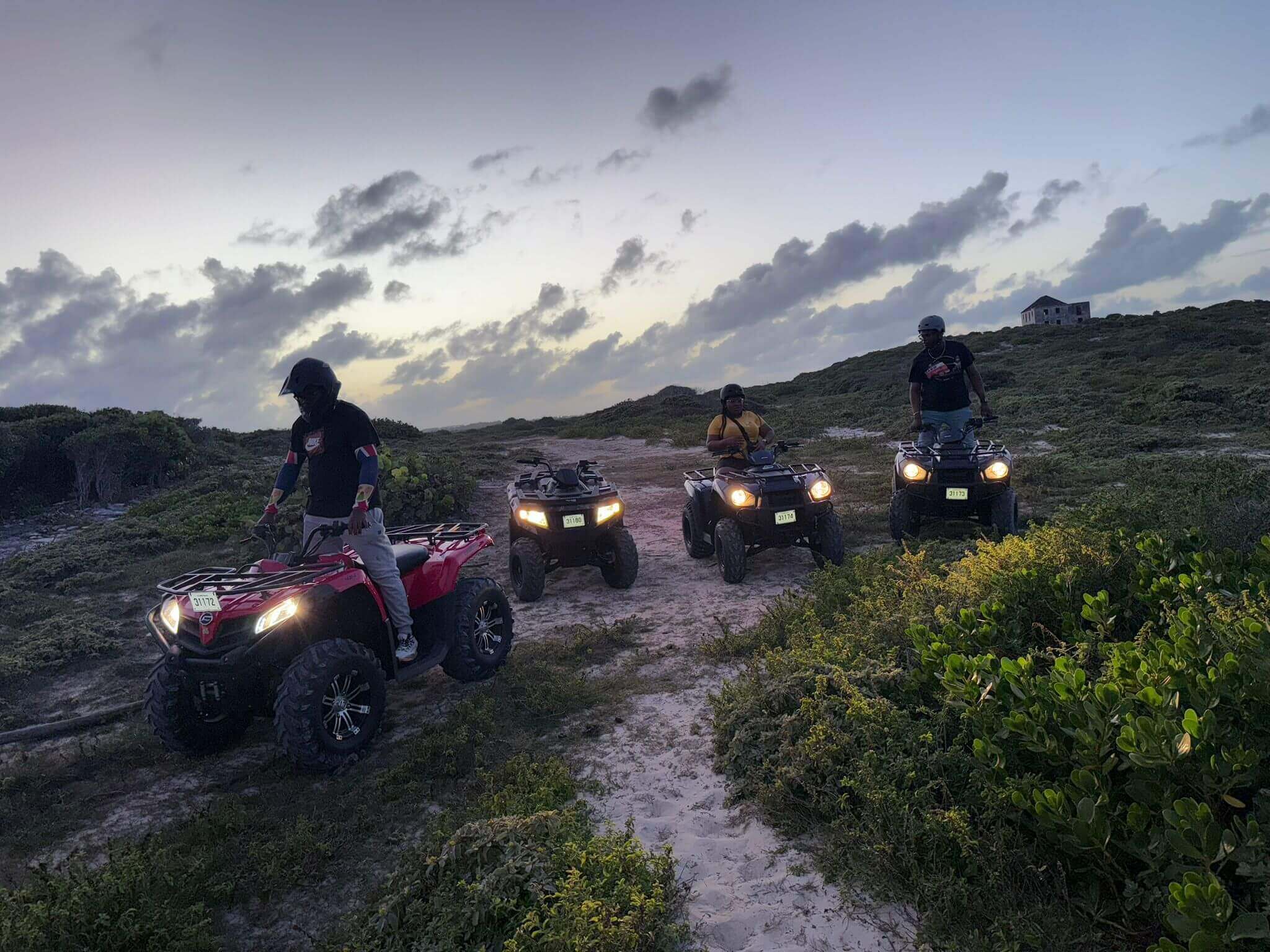 ATV riders exploring scenic coastal trail during sunset adventure.